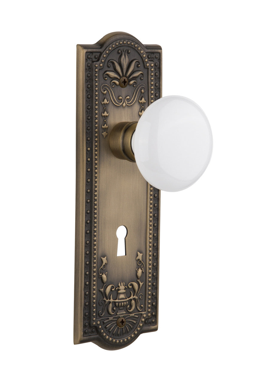 Nostalgic 701875: Meadows Backplate w/White Porcelain Knob Passage Door Set - Antique Brass