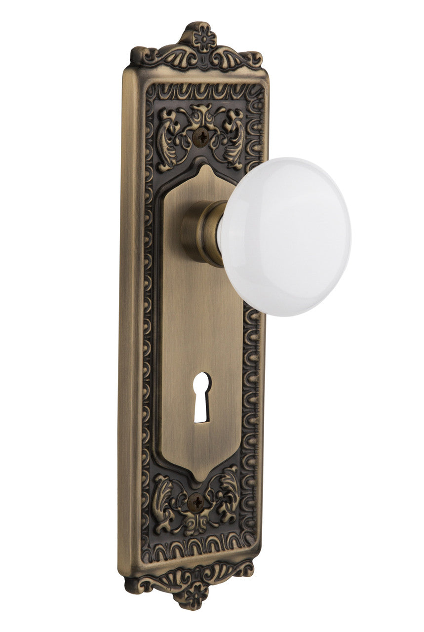 Nostalgic 701964: Egg & Dart Backplate w/White Porcelain Knob Single Dummy Door Set - Antique Brass