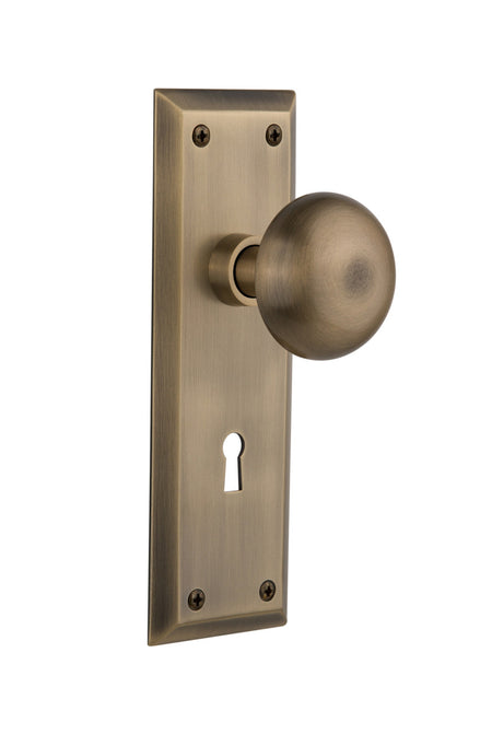 Nostalgic 704544: New York Backplate w/New York Knob Passage Door Set - Antique Brass