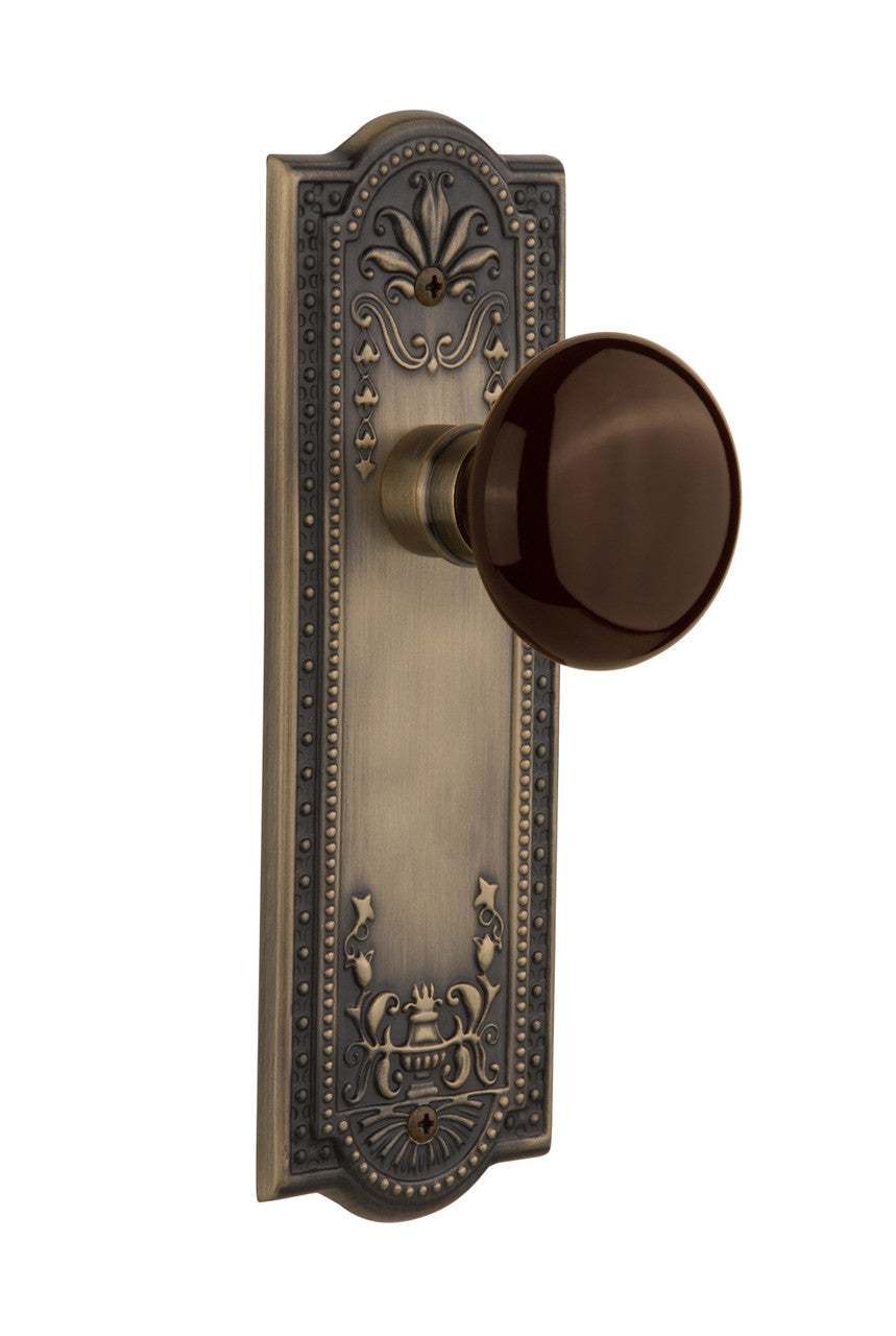 Nostalgic 710454: Meadows Backplate w/Brown Porcelain Knob Passage Door Set - Antique Brass