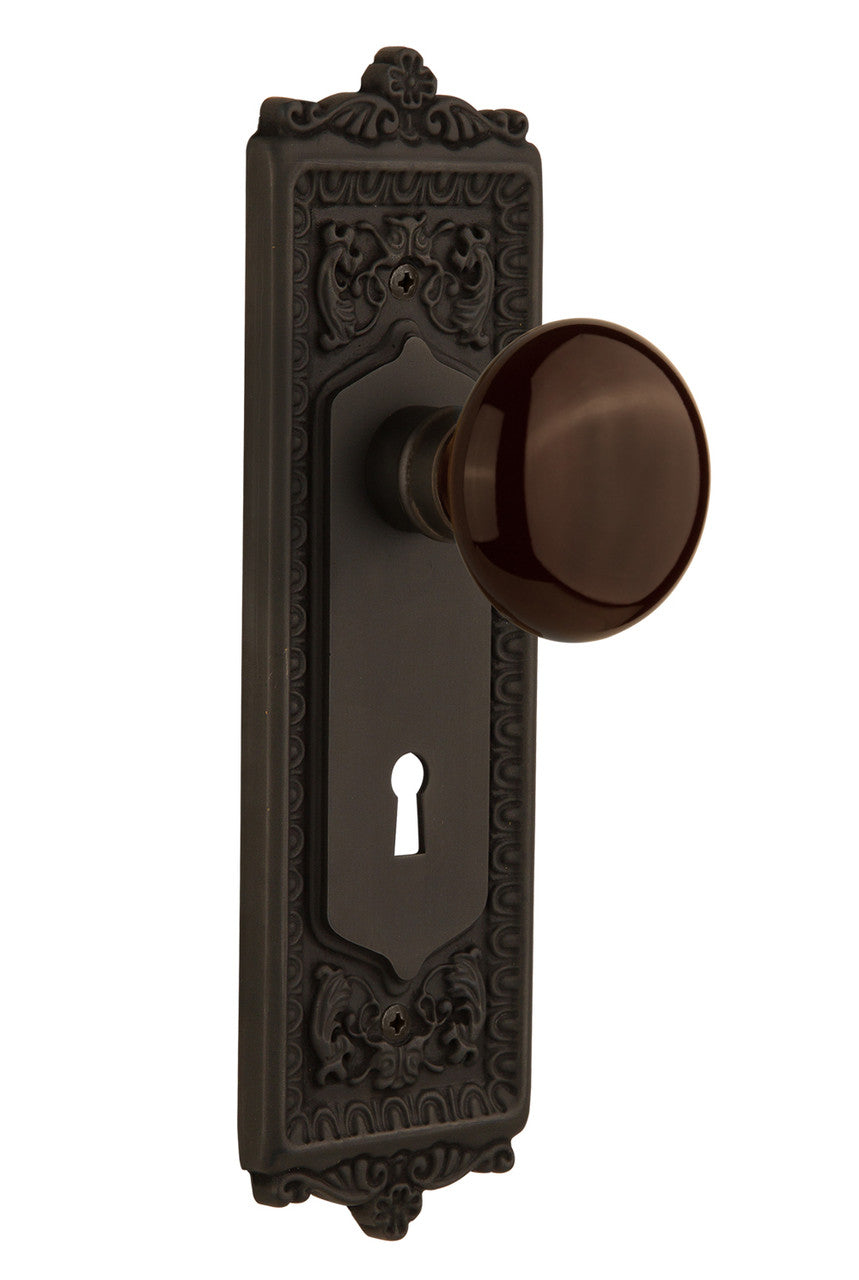Nostalgic 710504: Egg & Dart Backplate w/Brown Porcelain Knob Passage Door Set - Oil-Rubbed Bronze