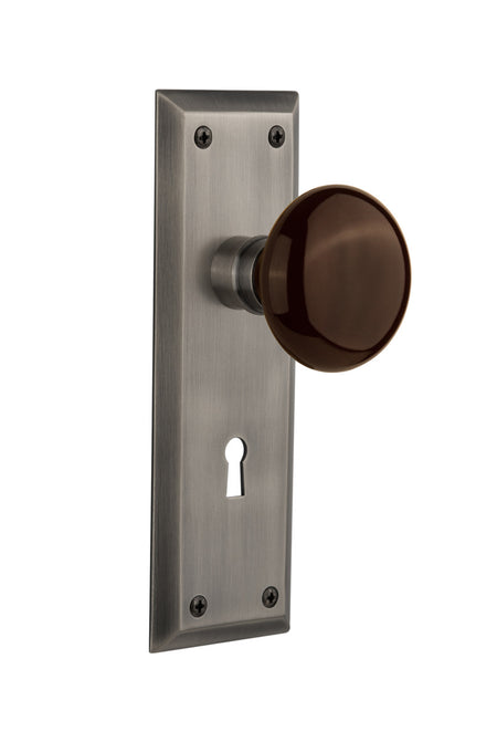 Nostalgic 710516: New York Backplate w/Brown Porcelain Knob Passage Door Set - Antique Pewter
