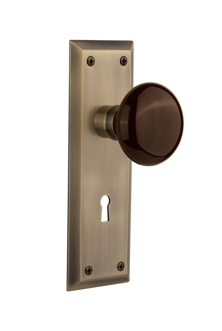 Nostalgic 710611: New York Backplate w/Brown Porcelain Knob Single Dummy Door Set - Antique Brass