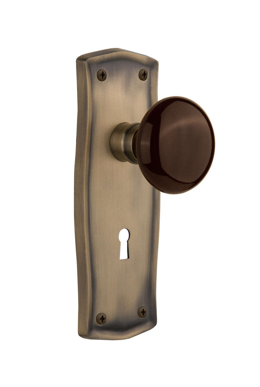 Nostalgic 710810: Prairie Backplate w/Brown Porcelain Knob Privacy Door Set - Antique Brass