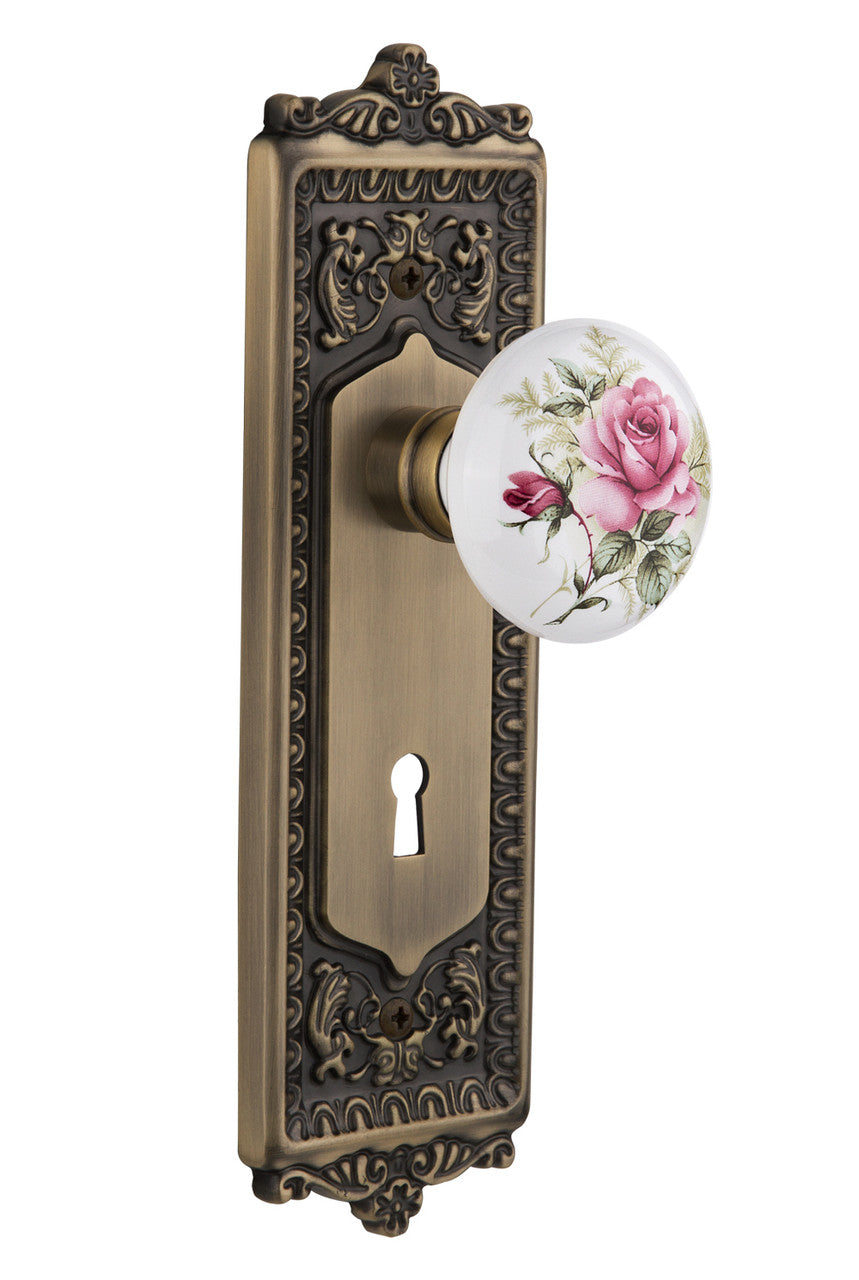 Nostalgic 711229: Egg & Dart Backplate w/White Rose Porcelain Knob Privacy Door Set - Antique Brass