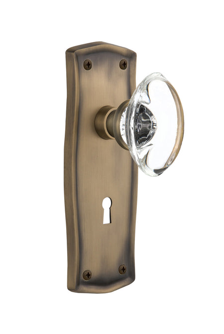 Nostalgic 711402: Prairie Backplate w/Oval Clear Glass Crystal Knob Passage Door Set - Antique Brass
