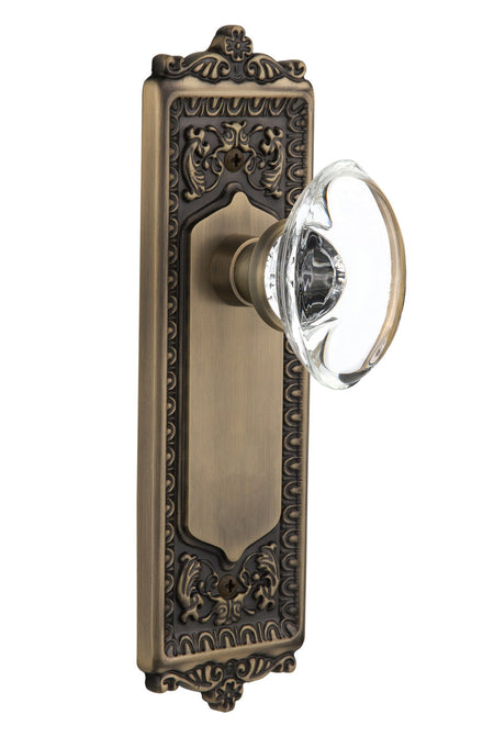 Nostalgic 711423: Egg & Dart Backplate w/Oval Clear Glass Crystal Knob Single Dummy Door Set - Antique Brass