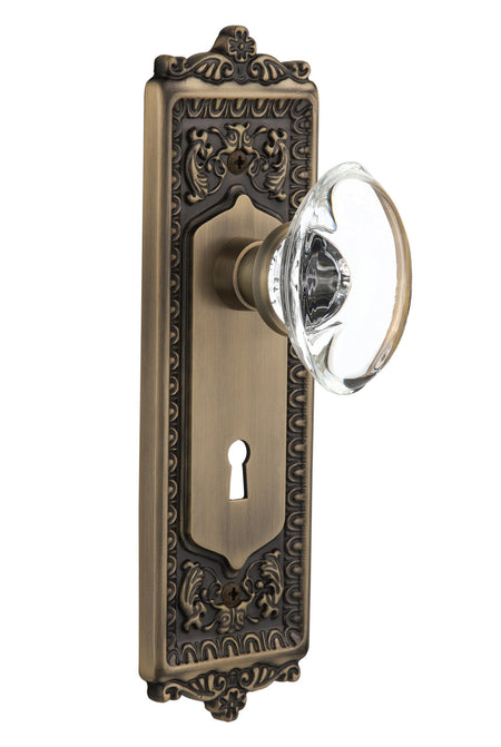 Nostalgic 711477: Egg & Dart Backplate w/Oval Clear Glass Crystal Knob Single Dummy Door Set - Antique Brass