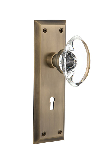 Nostalgic 711683: New York Backplate w/Oval Clear Glass Crystal Knob Privacy Door Set - Antique Brass