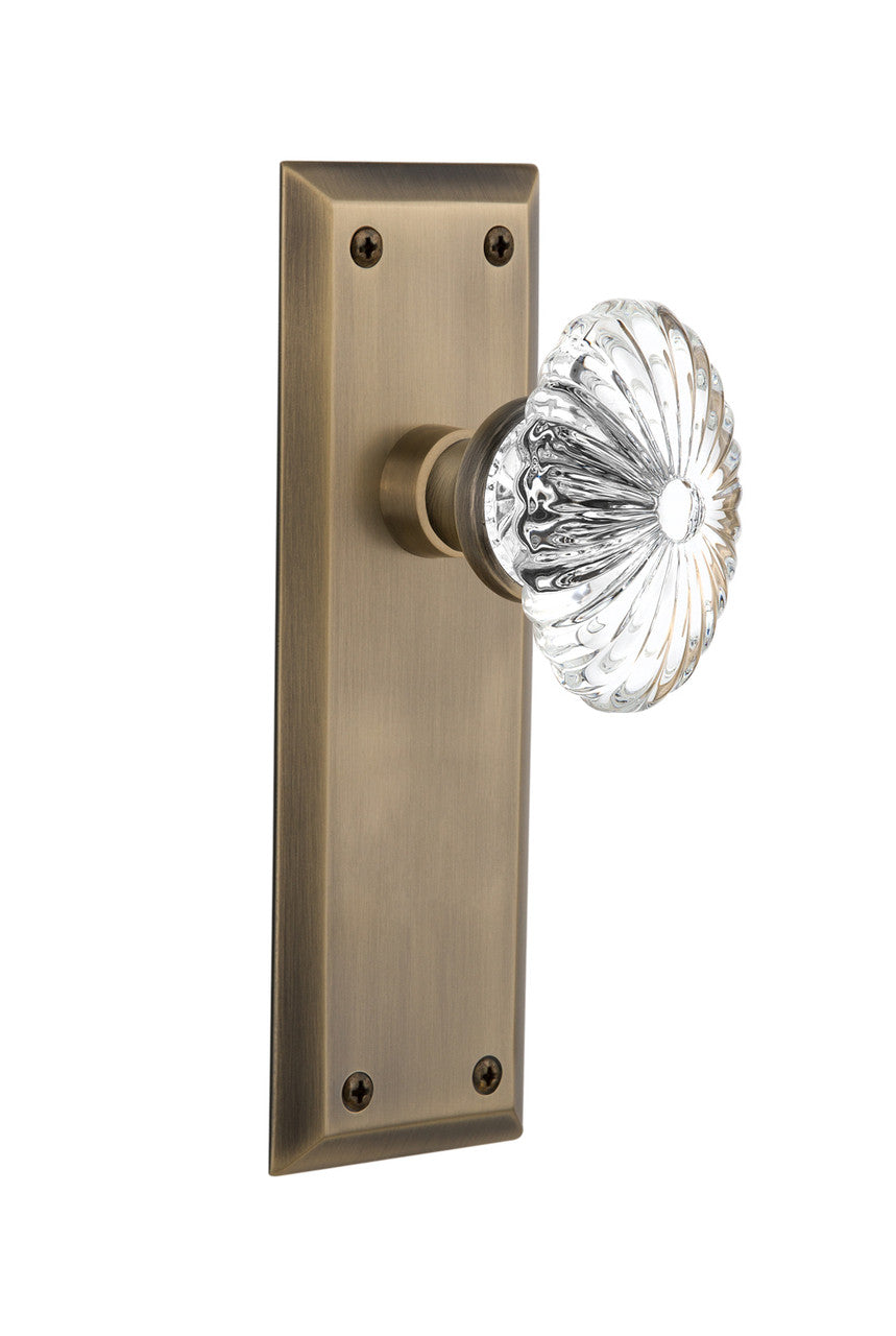 Nostalgic 711781: New York Backplate w/Oval Fluted Clear Glass Crystal Knob Passage Door Set - Antique Brass