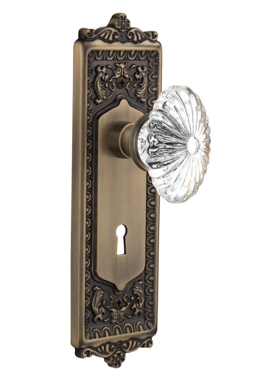 Nostalgic 712109: Egg & Dart Backplate w/Oval Fluted Clear Glass Crystal Knob Privacy Door Set - Antique Brass