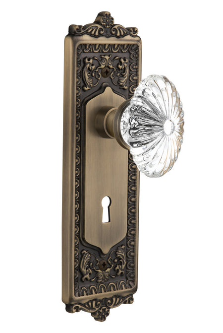 Nostalgic 712109: Egg & Dart Backplate w/Oval Fluted Clear Glass Crystal Knob Privacy Door Set - Antique Brass
