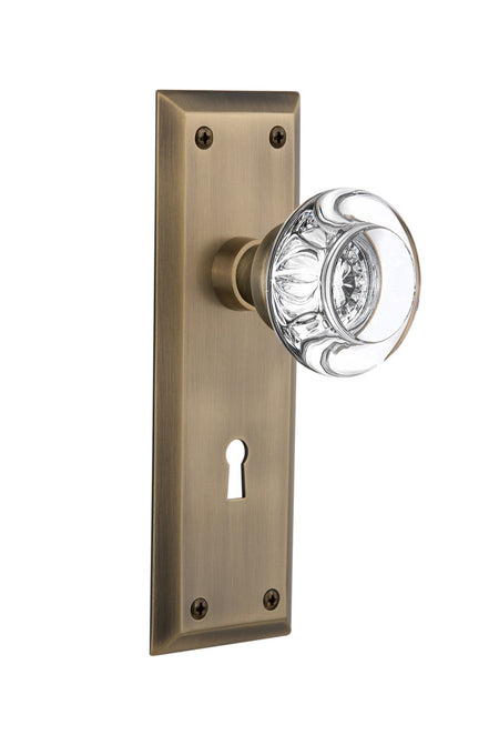 Nostalgic 712275: New York Backplate w/Round Clear Glass Crystal Knob Passage Door Set - Antique Brass