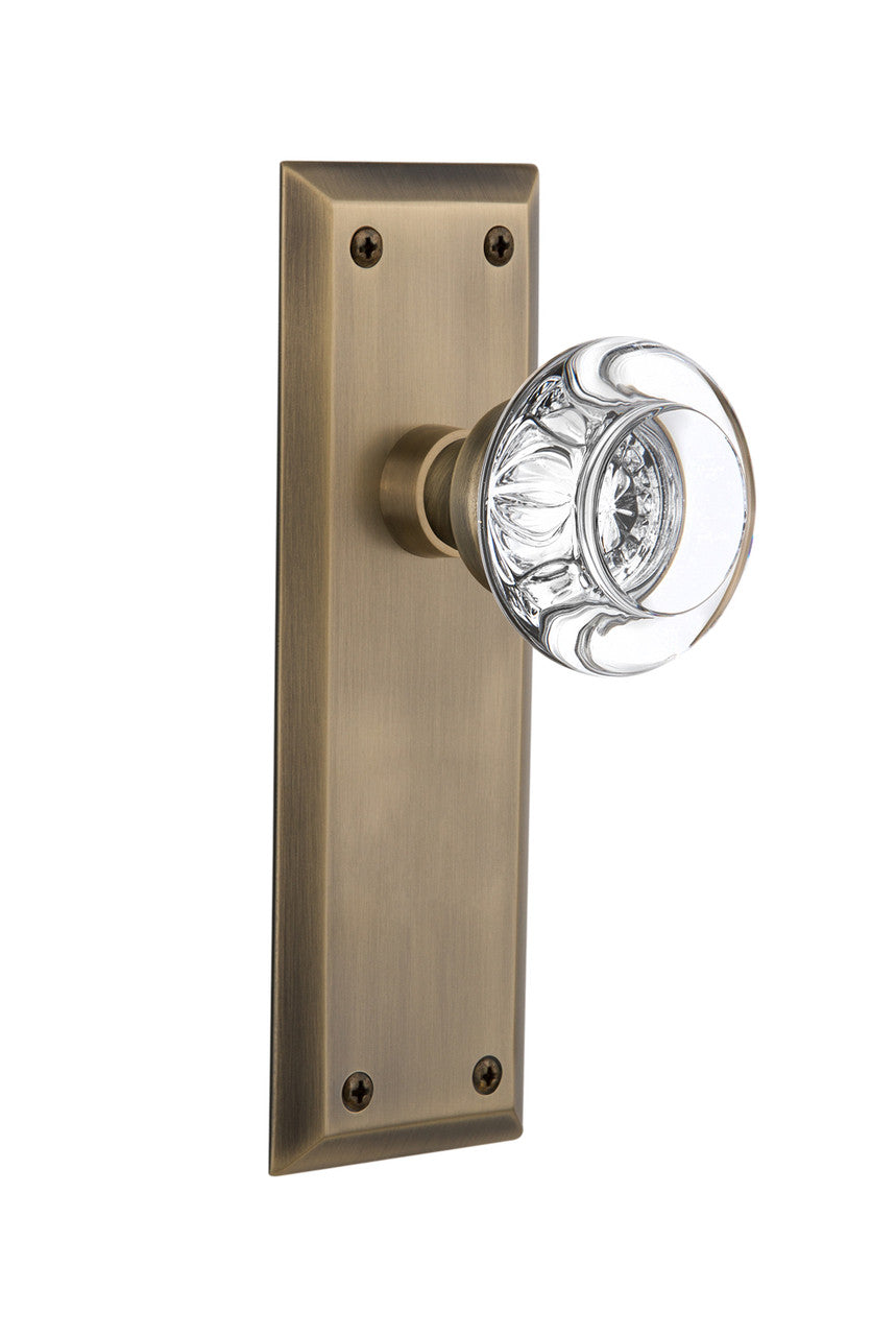 Nostalgic 712317: New York Backplate w/Round Clear Glass Crystal Knob Single Dummy Door Set - Antique Brass