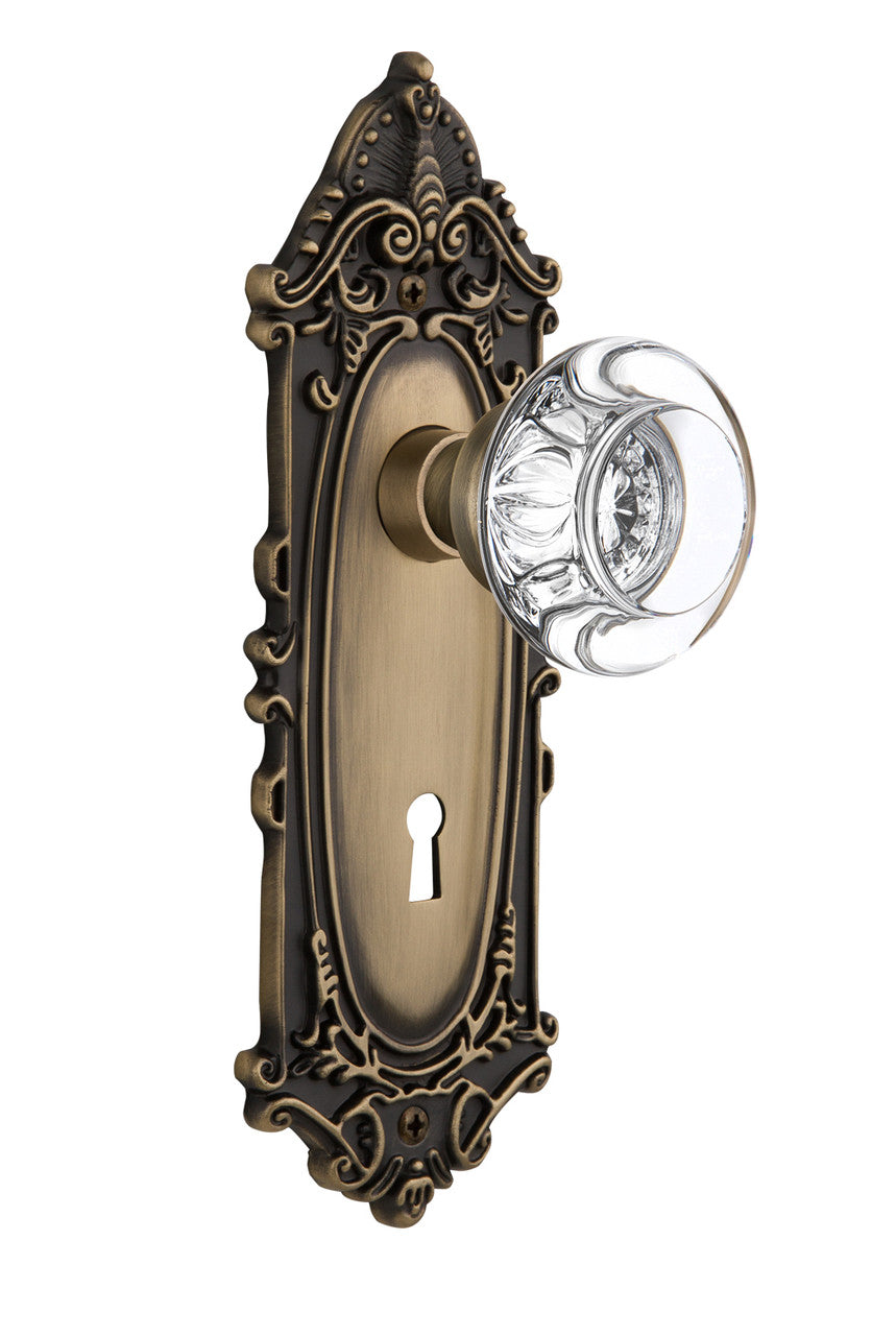 Nostalgic 712577: Victorian Backplate w/Round Clear Glass Crystal Knob Privacy Door Set - Antique Brass