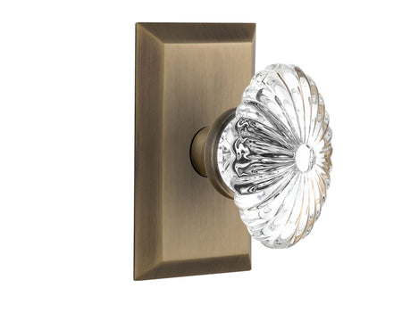 Nostalgic 713249: Studio Backplate w/Oval Fluted Clear Glass Crystal Knob Passage Door Set - Antique Brass