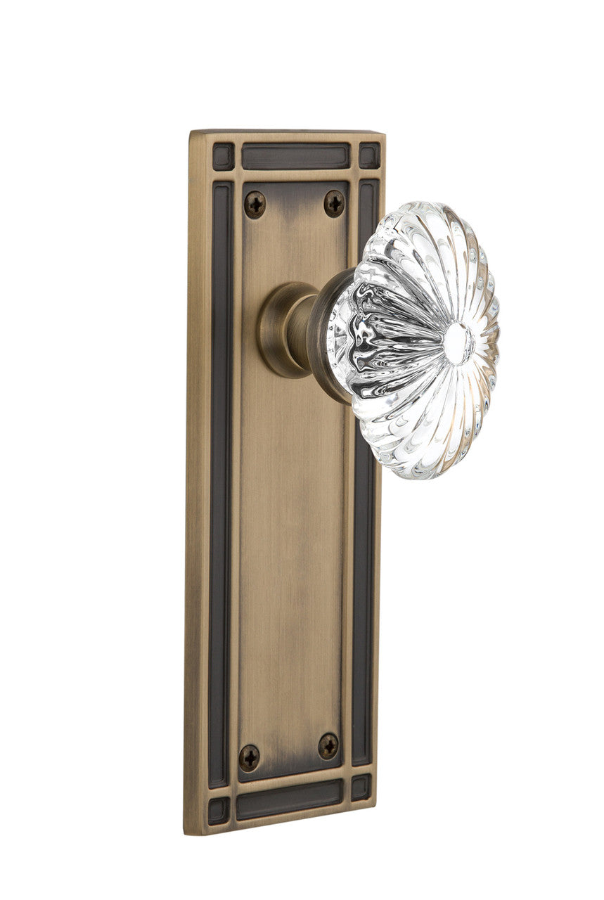 Nostalgic 715850: Mission Backplate w/Oval Fluted Clear Glass Crystal Knob Passage Door Set - Antique Brass