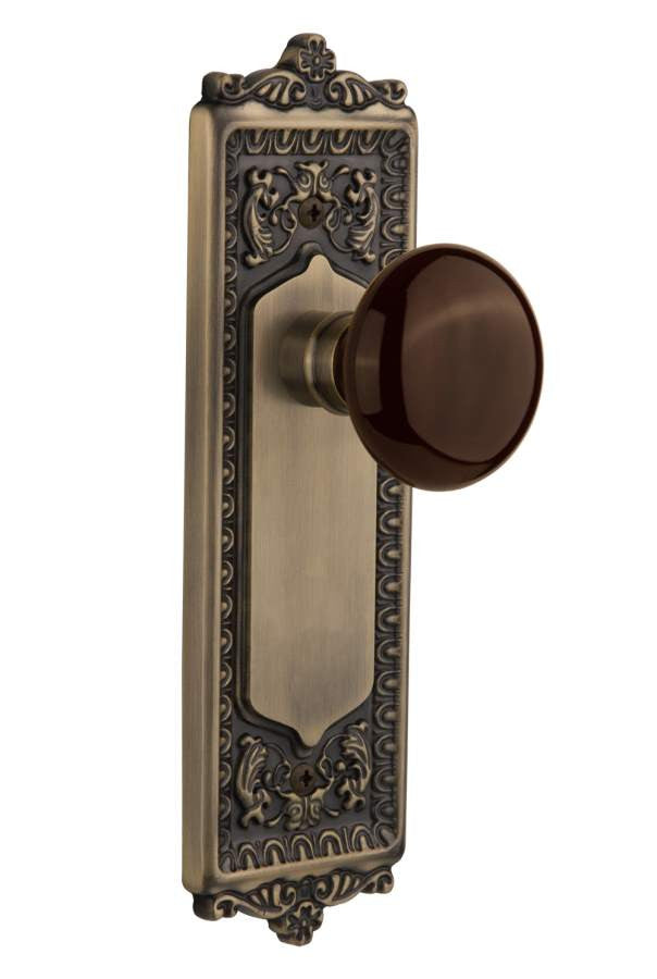Nostalgic 710447: Egg & Dart Backplate w/Brown Porcelain Knob Passage Door Set - Antique Brass