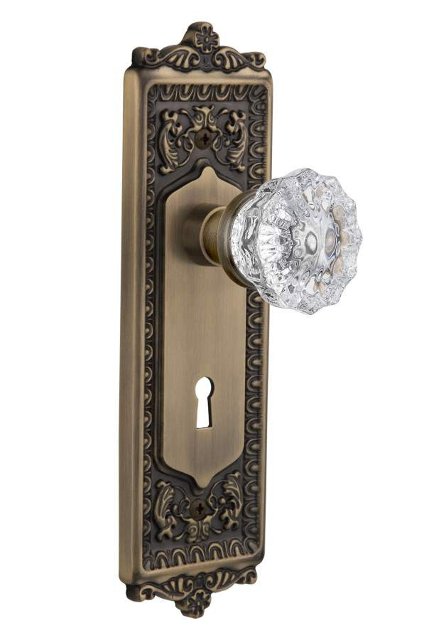 Nostalgic 701933: Egg & Dart Backplate w/Clear Crystal Glass Knob Passage Door Set - Antique Brass
