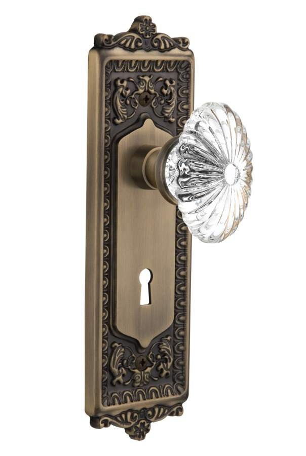 Nostalgic 712109: Egg & Dart Backplate w/Oval Fluted Clear Glass Crystal Knob Privacy Door Set - Antique Brass
