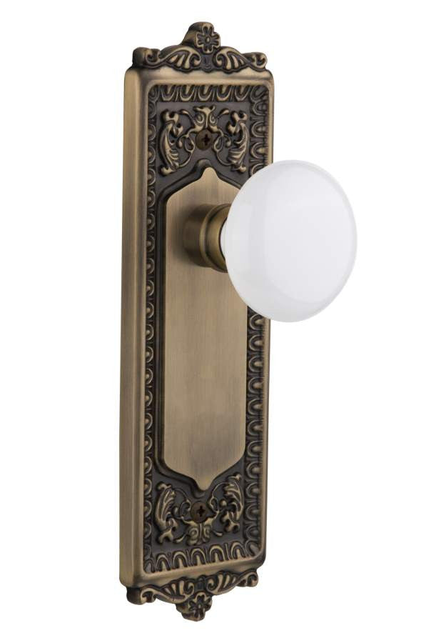 Nostalgic 701996: Egg & Dart Backplate w/White Porcelain Knob Passage Door Set - Antique Brass