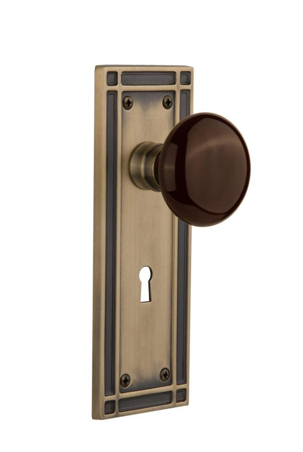 Nostalgic 715906: Mission Backplate w/Brown Porcelain Knob Passage Door Set - Antique Brass