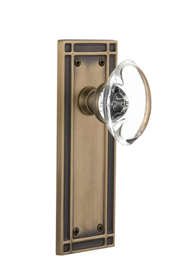 Nostalgic 715974: Mission Backplate w/Oval Clear Glass Crystal Knob Single Dummy Door Set - Antique Brass