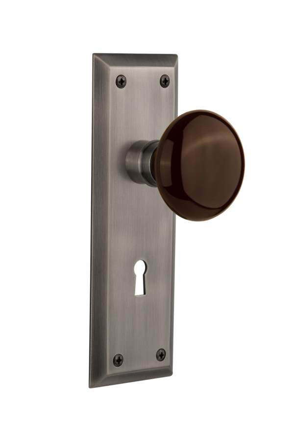 Nostalgic 710516: New York Backplate w/Brown Porcelain Knob Passage Door Set - Antique Pewter