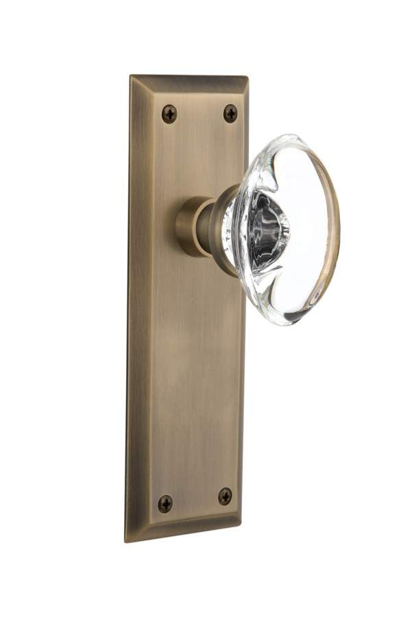 Nostalgic 711629: New York Backplate w/Oval Clear Glass Crystal Knob Privacy Door Set - Antique Brass
