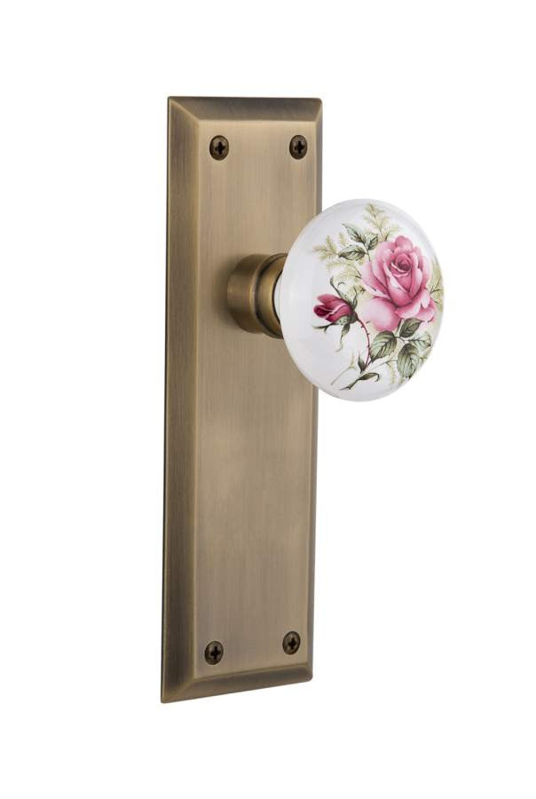 Nostalgic 710901: New York Backplate w/White Rose Porcelain Knob Passage Door Set - Antique Brass
