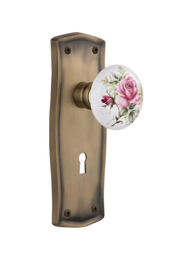 Nostalgic 710962: Prairie Backplate w/White Rose Porcelain Knob Passage Door Set - Antique Brass
